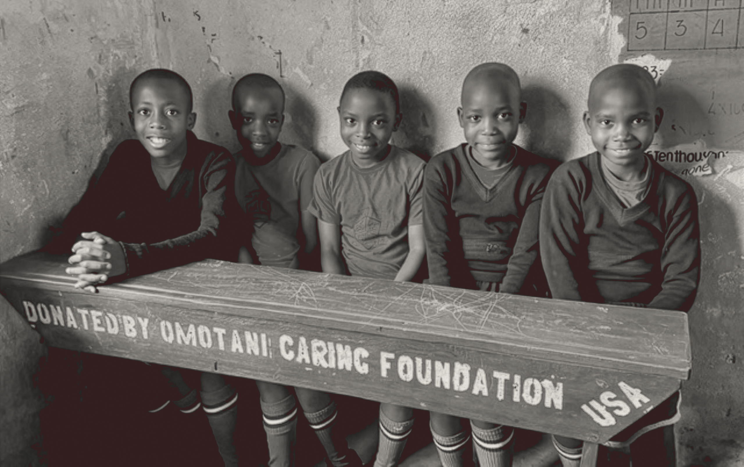 Children with desk donated by Omotani Caring Foundation